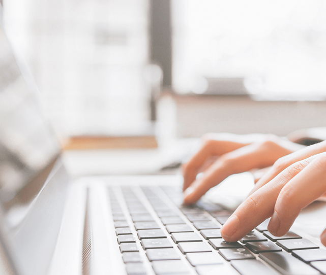 Distance education. Online college training. Remote student learning. Closeup of hands typing on laptop.